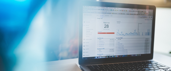 MacBook Pro on brown table showing google analytics website